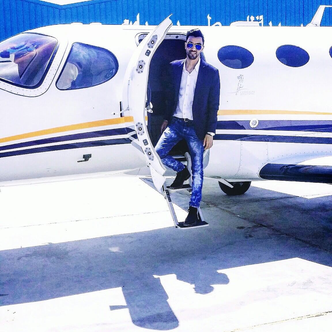 Subject posing at the open door of a business jet